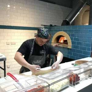 Pizzaiolo con forno PVP a gas sullo sfondo