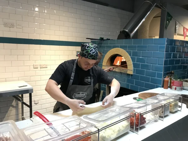Pizzaiolo con forno PVP a gas sullo sfondo