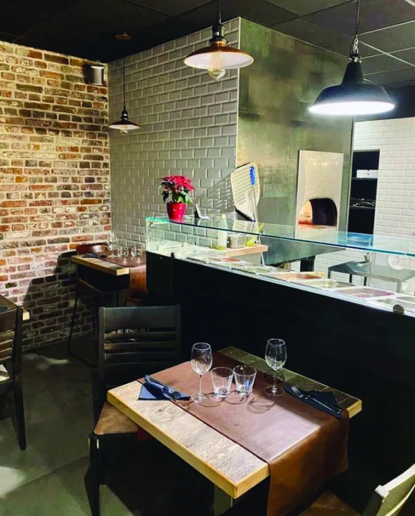 Tavolo di ristorante con forno Twister 130 legna sullo sfondo